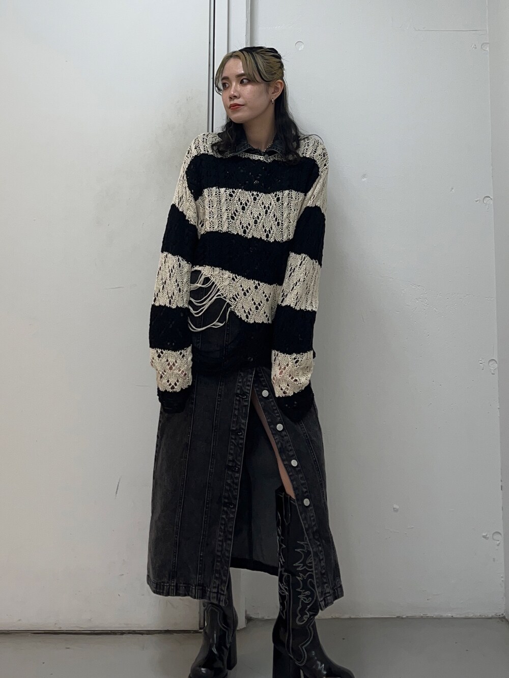 ブラック系のニット/セーター、ブラック系のワンピース、ブラック系のブーツを着用したレディースの冬コーディネートの3枚目の写真