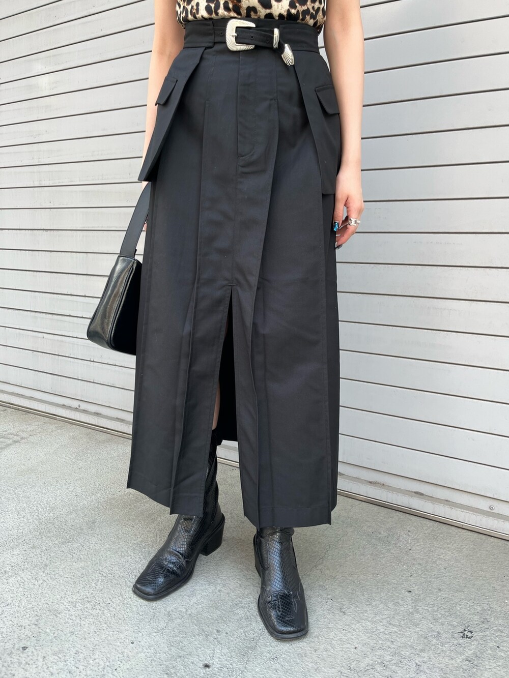 ブラック系のスカート、ブラック系のハンドバッグ、ベージュ系のTシャツ/カットソーを着用したレディースの春コーディネートの8枚目の写真