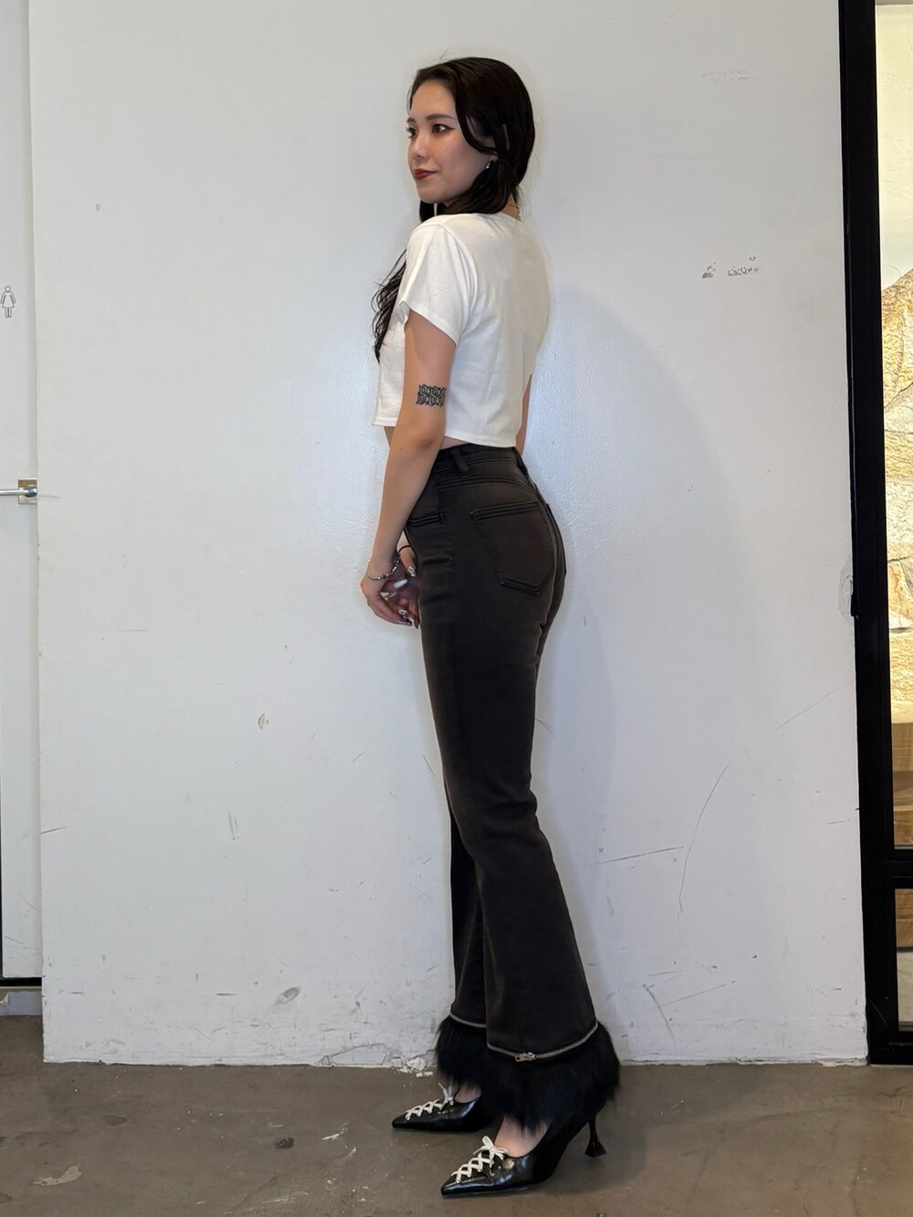 ホワイト系のTシャツ/カットソー、ブラック系のデニムパンツ、ブラック系のパンプスを着用したレディースの夏コーディネートの3枚目の写真