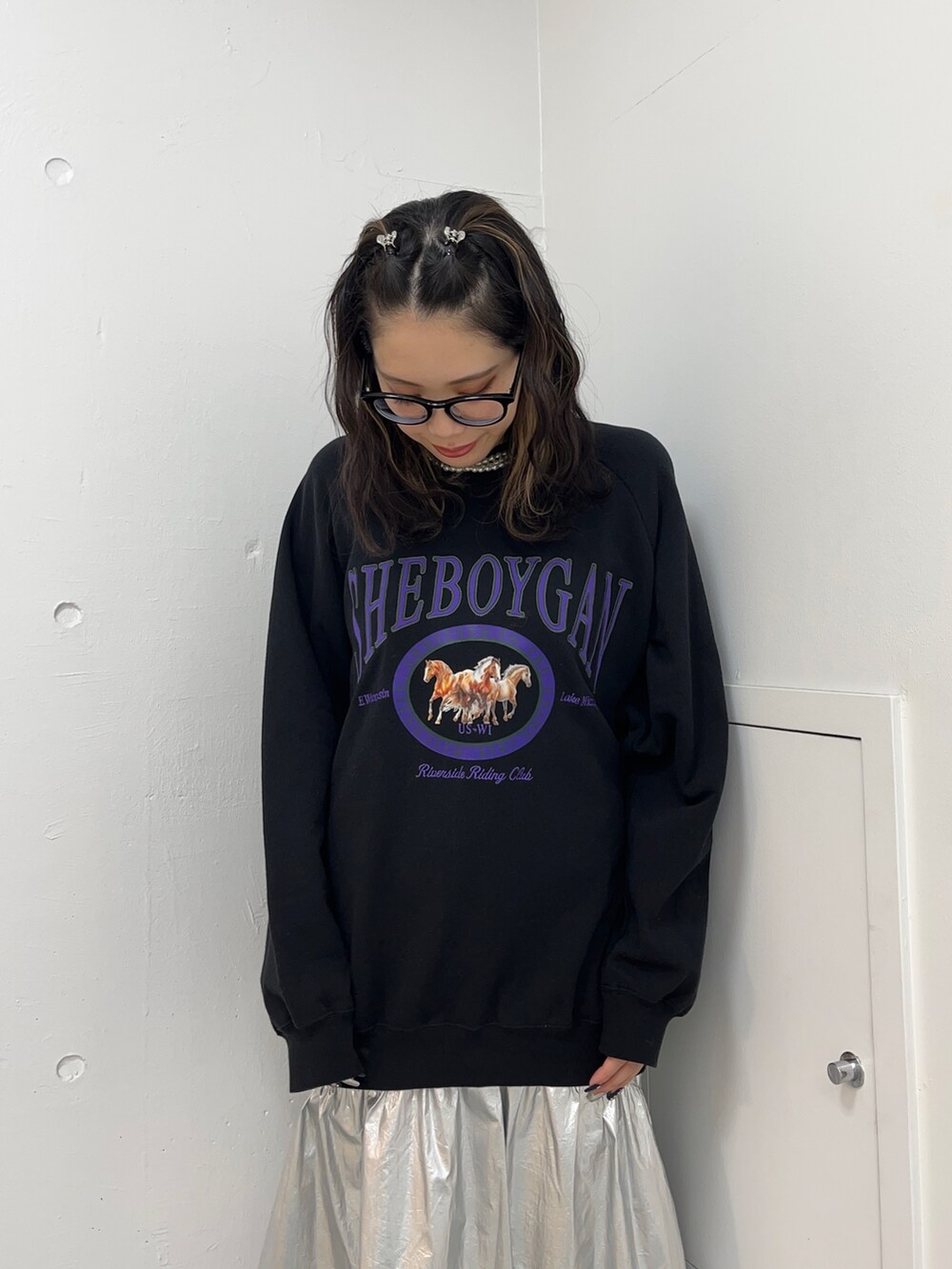 ブラック系のスウェット、シルバー系のスカート、ブラック系のブーツを着用したレディースの冬コーディネートの4枚目の写真