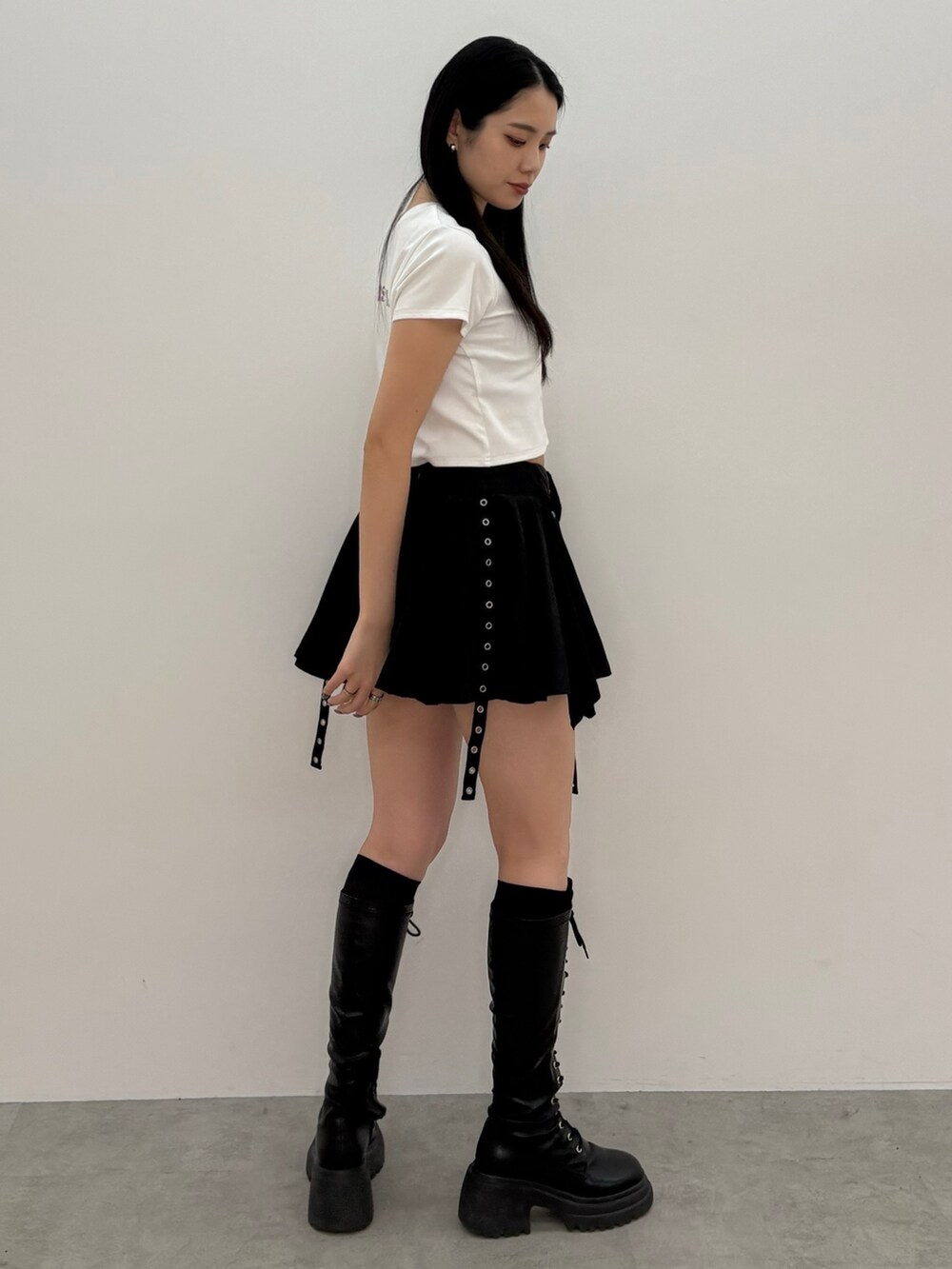 ブラック系のスカート、ホワイト系のTシャツ/カットソーを着用したレディースの春コーディネートの2枚目の写真