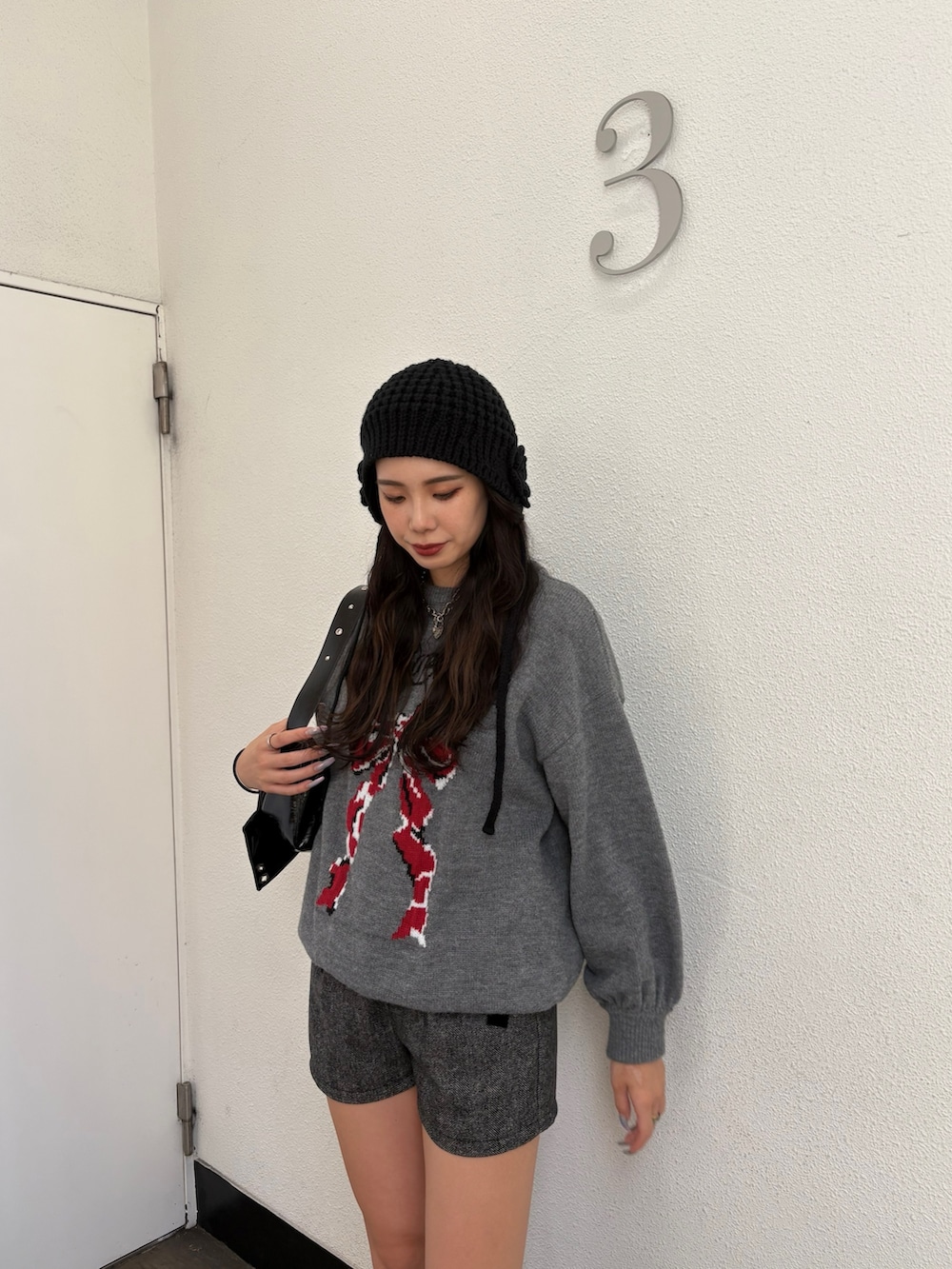 グレー系のニット/セーター、グレー系のその他パンツ、ブラック系のショルダーバッグを着用したレディースの秋コーディネートの4枚目の写真