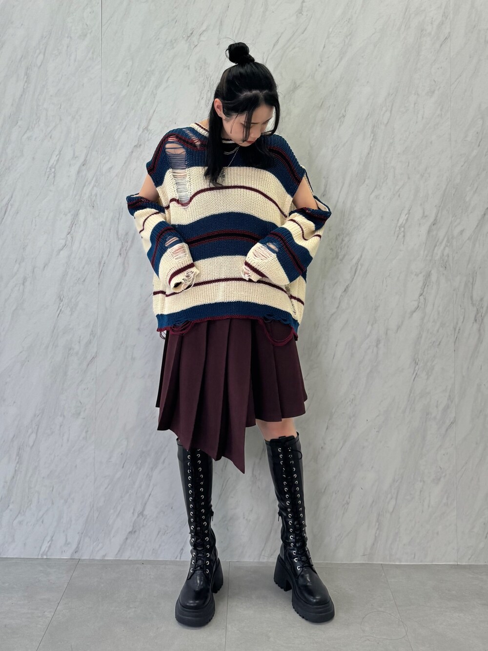 ホワイト系のニット/セーター、レッド系のスカート、ブラック系のブーツを着用したレディースの春コーディネートの2枚目の写真