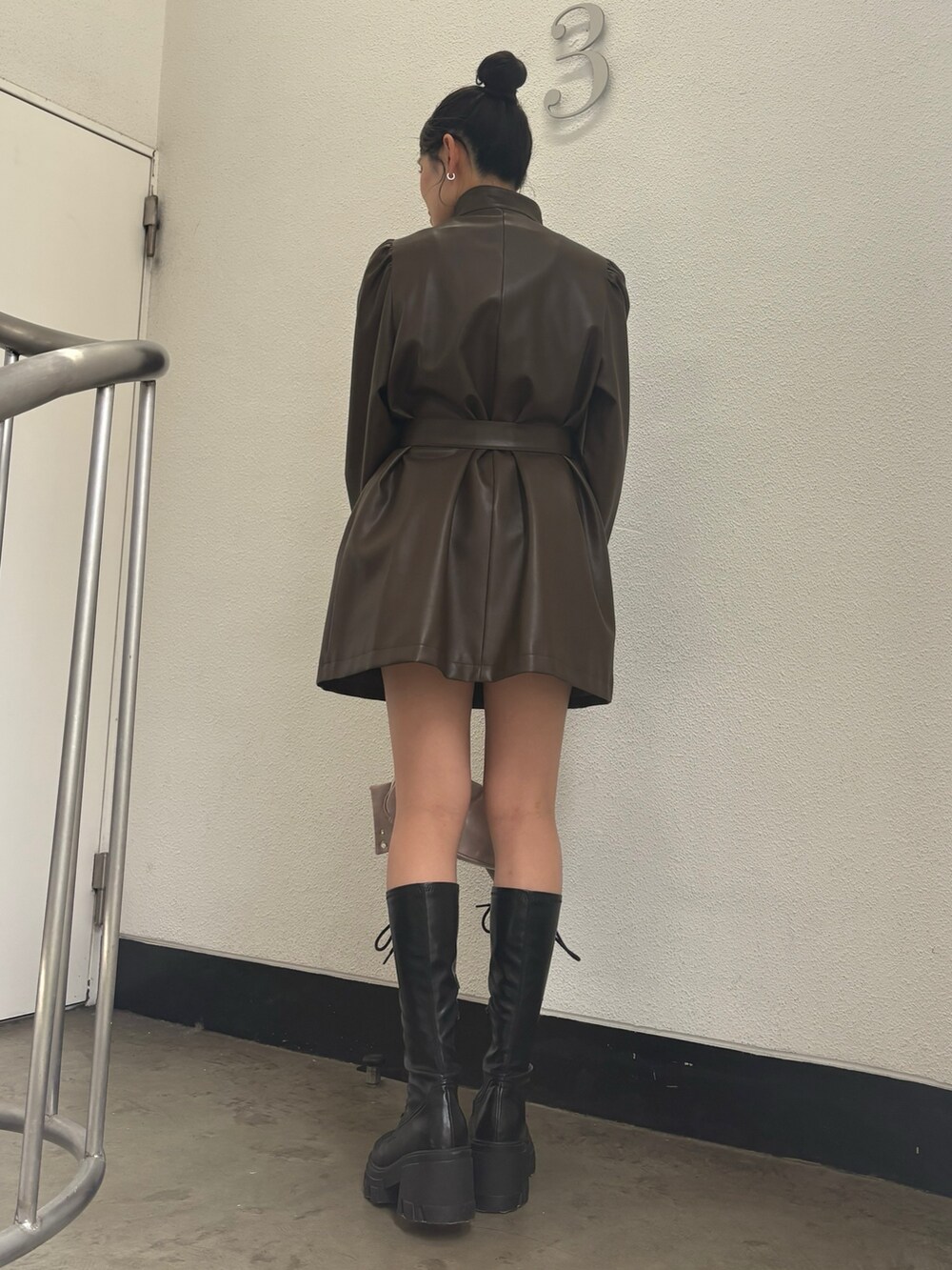 ブラウン系のその他アウター、ブラック系のブーツ、ピンク系のショルダーバッグを着用したレディースの秋コーディネートの3枚目の写真