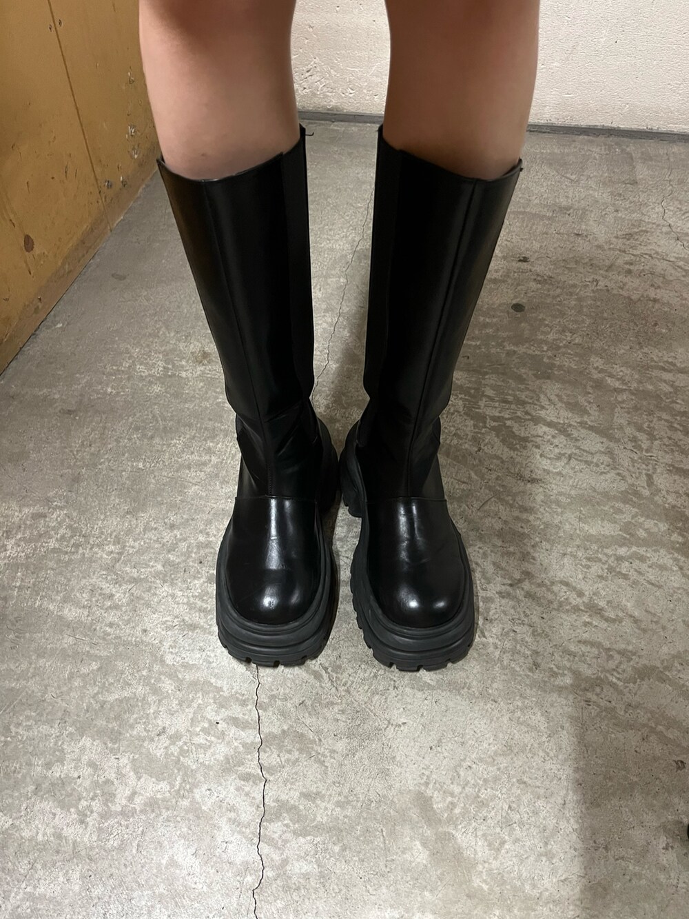 ブルー系のカーディガン/ボレロ、ブラック系のスカート、ブラック系のブーツを着用したレディースの冬コーディネートの6枚目の写真