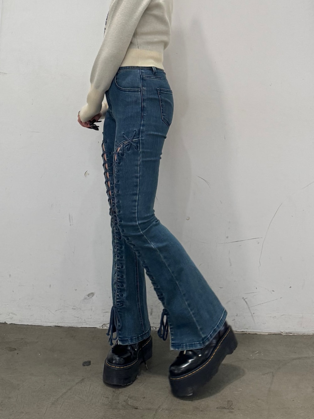 ホワイト系のニット/セーター、ブルー系のデニムパンツを着用したレディースの秋コーディネートの6枚目の写真