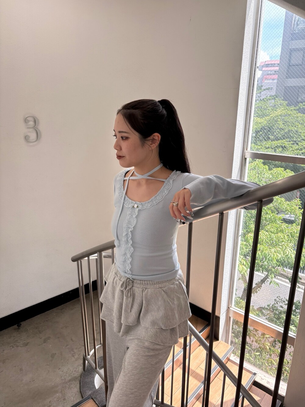 ブルー系のニット/セーター、グレー系のスウェットパンツを着用したレディースの夏コーディネートの7枚目の写真