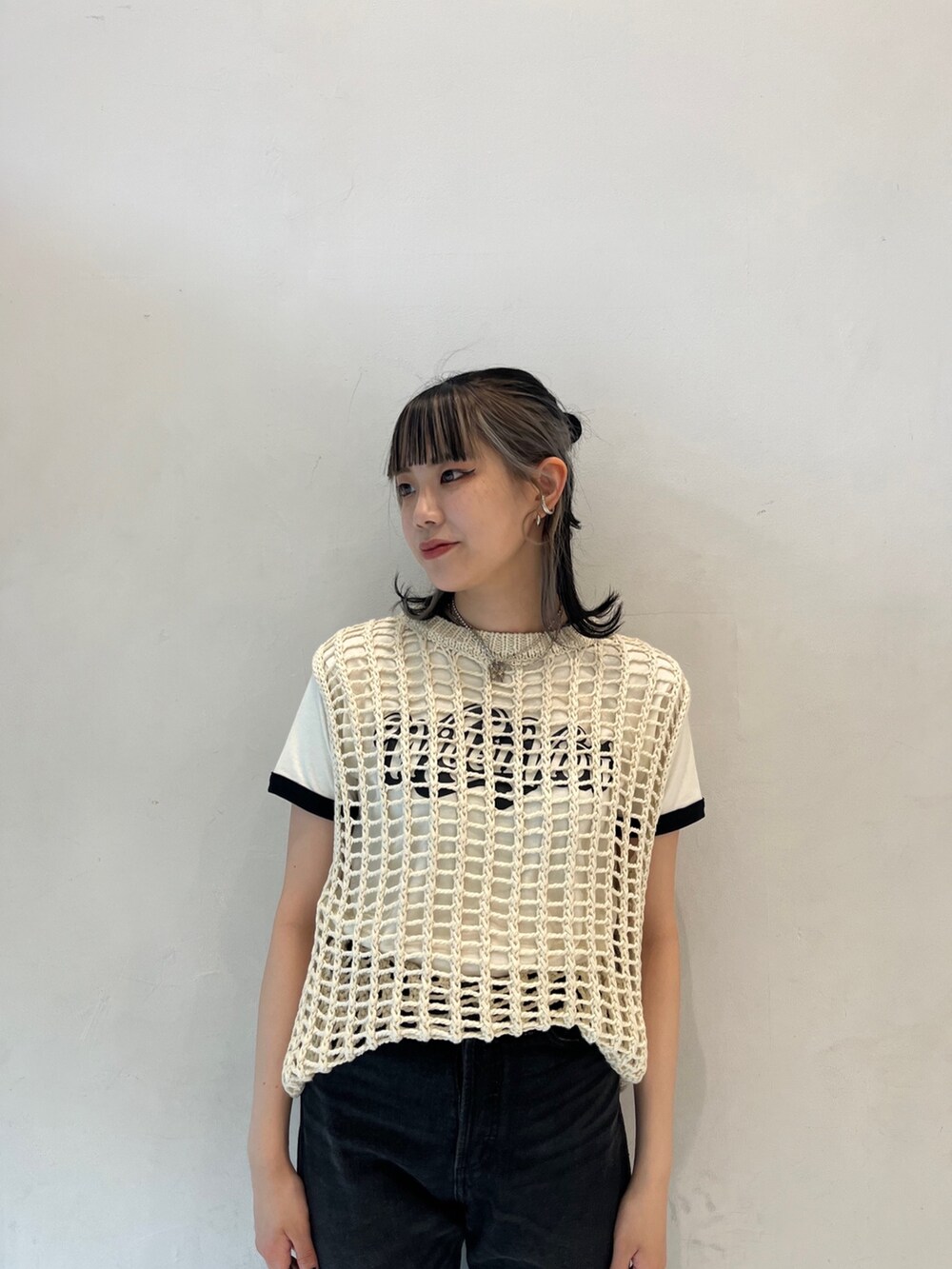 ブラック系のデニムパンツ、ホワイト系のTシャツ/カットソー、ホワイト系のベストを着用したレディースの春コーディネートの4枚目の写真