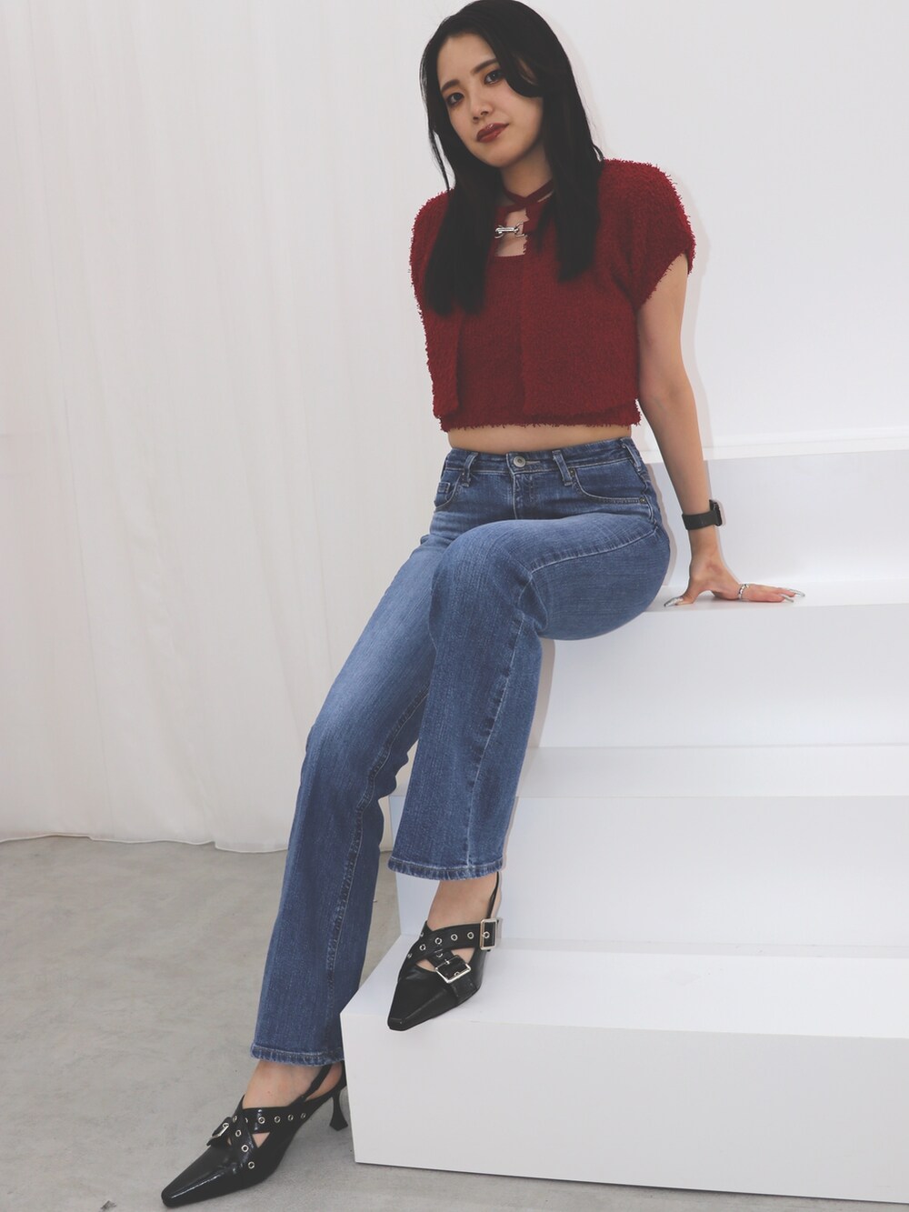 ブルー系のデニムパンツ、レッド系のアンサンブル、ブラック系のパンプスを着用したレディースの夏コーディネートの4枚目の写真