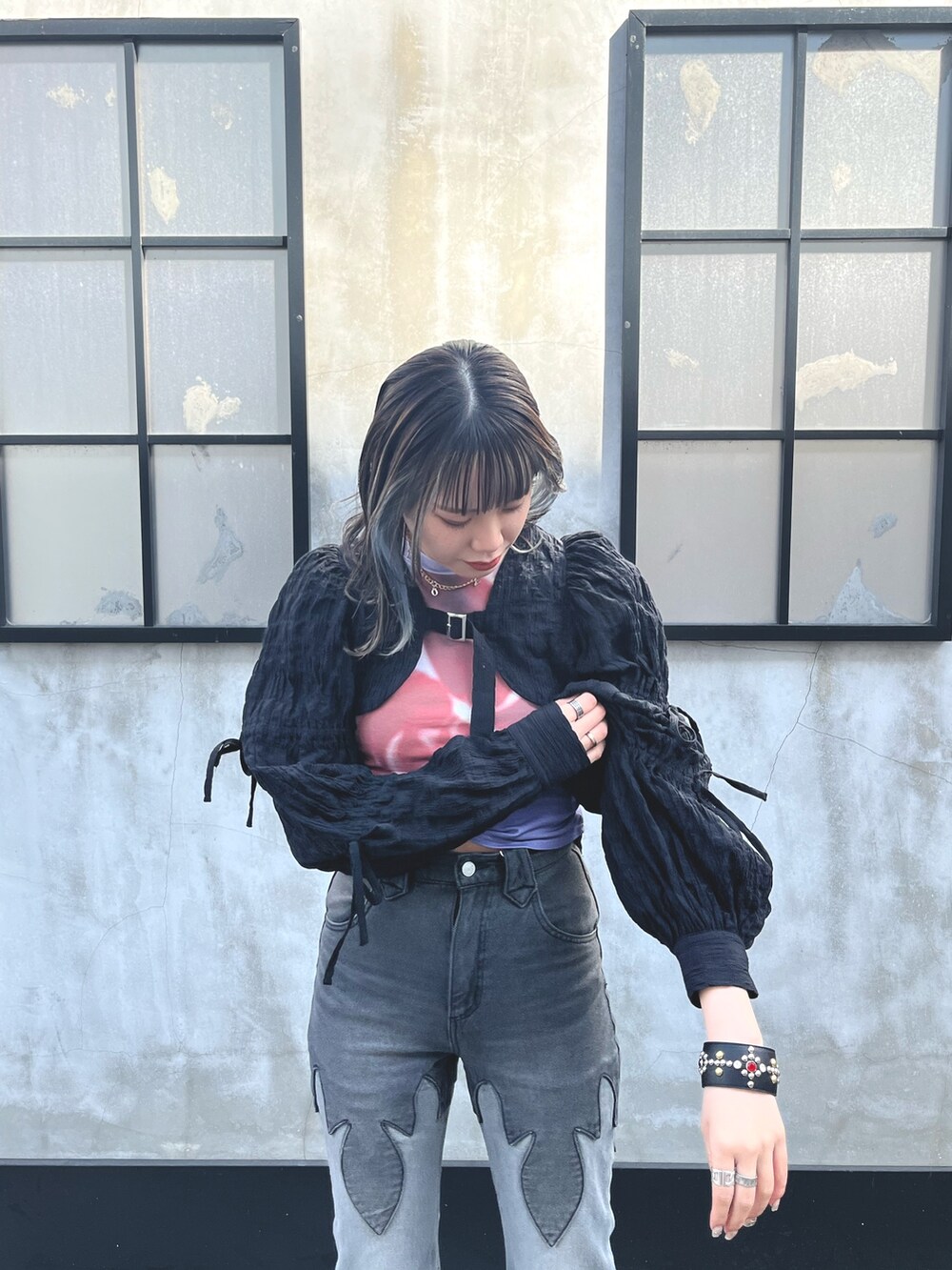 ブラック系のデニムパンツ、ブラック系のカーディガン/ボレロ、パープル系のTシャツ/カットソーを着用したレディースの春コーディネートの4枚目の写真