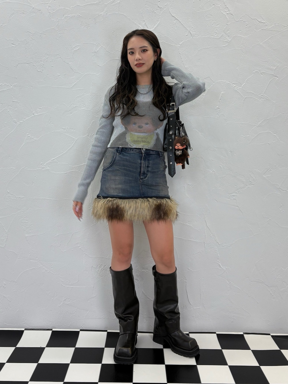 ブルー系のニット/セーター、ブラック系のショルダーバッグ、ブルー系のスカートを着用したレディースの夏コーディネートの2枚目の写真