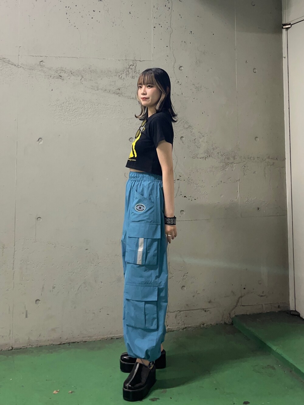 ブルー系のカーゴパンツ、ブラック系のサンダル、ブラック系のTシャツ/カットソーを着用したレディースの夏コーディネートの3枚目の写真