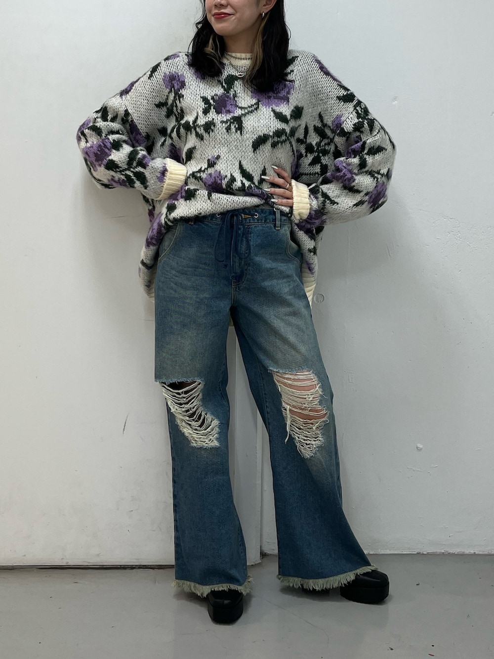 ブルー系のデニムパンツ、ブラック系のブーツ、ホワイト系のニット/セーターを着用したレディースの冬コーディネートの4枚目の写真