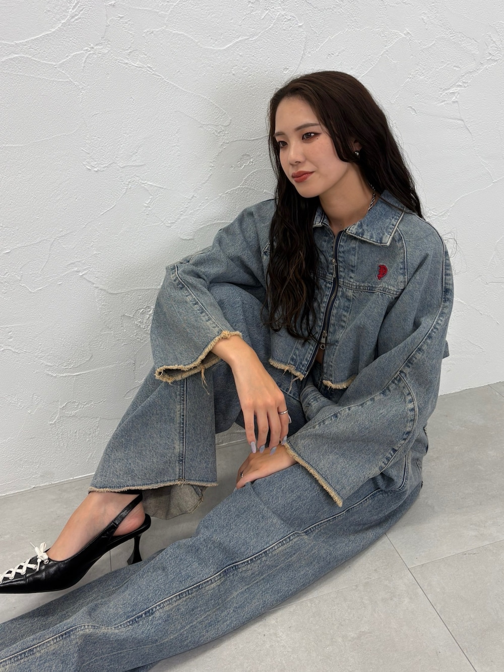 ブルー系のデニムジャケット、ブルー系のデニムパンツ、ブラック系のパンプスを着用したレディースの秋コーディネートの5枚目の写真