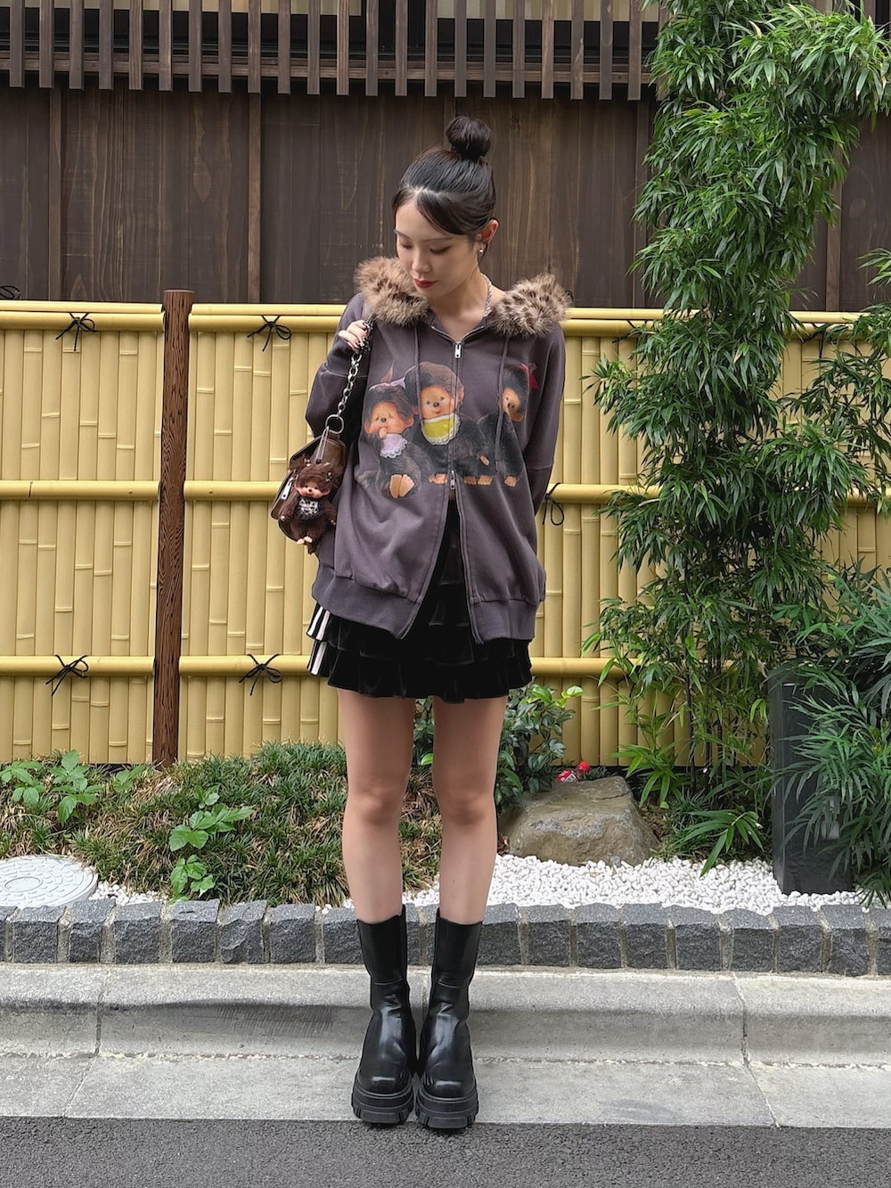 ブラック系のパーカー、ブラック系のスカート、ブラウン系のキーホルダーを着用したレディースの秋コーディネートの2枚目の写真