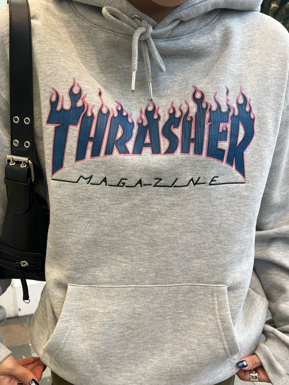 グリーン系のスカート、グレー系のパーカー、ブラック系のブーツを着用したレディースの冬コーディネートの4枚目の写真