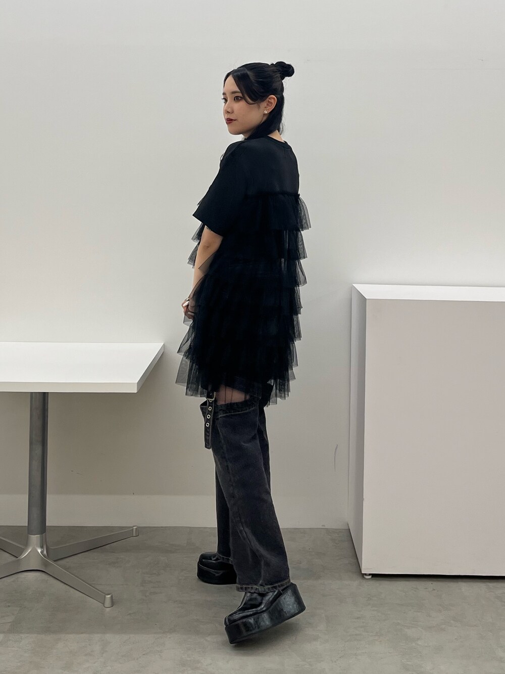 ブラック系のワンピース、ブラック系のデニムパンツを着用したレディースの春コーディネートの2枚目の写真