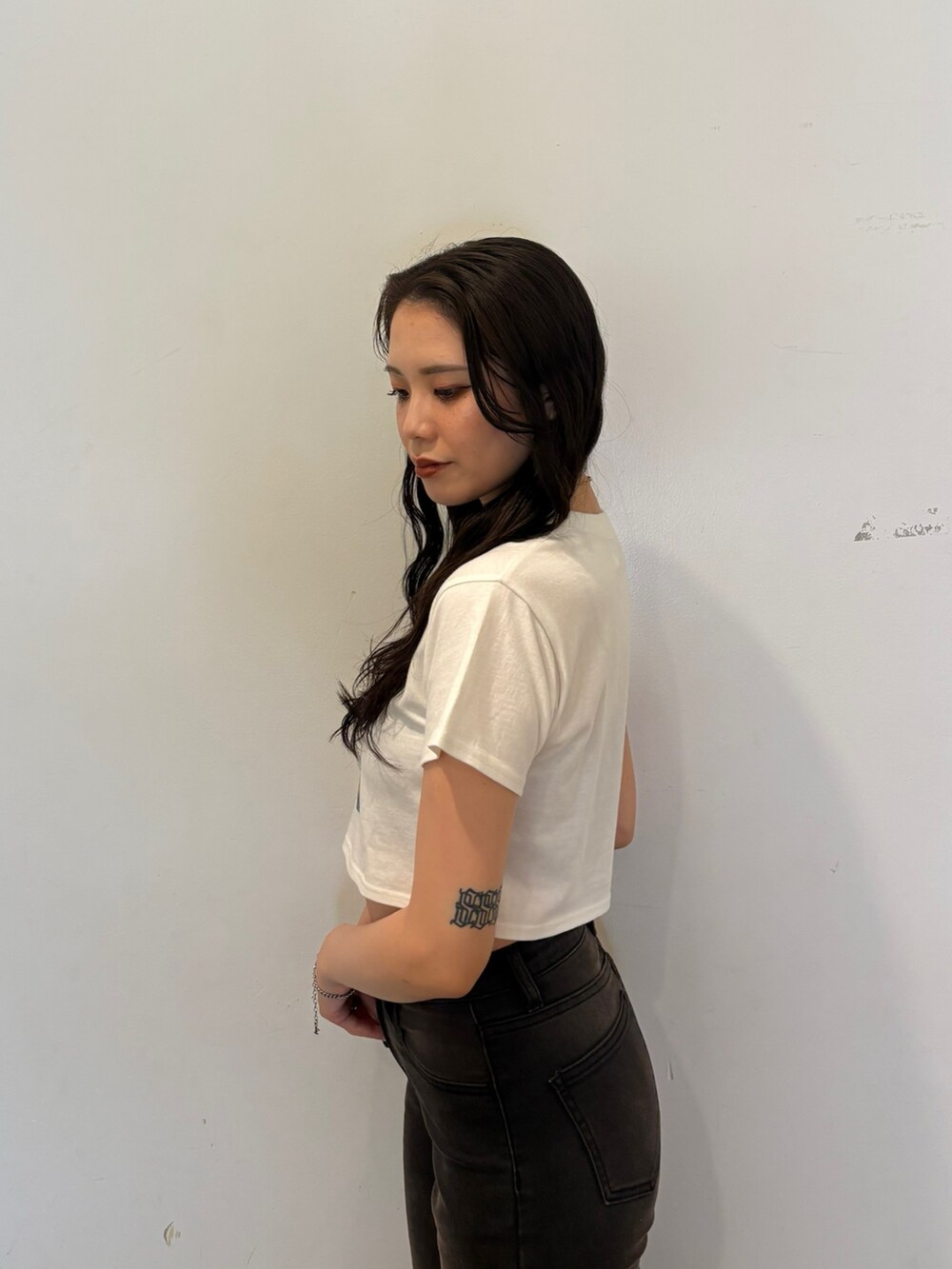 ホワイト系のTシャツ/カットソー、ブラック系のデニムパンツ、ブラック系のパンプスを着用したレディースの夏コーディネートの6枚目の写真