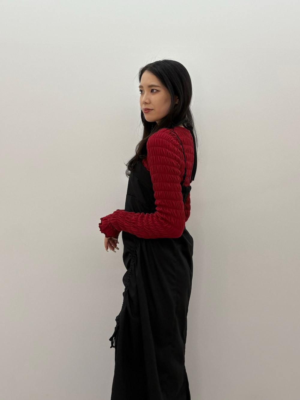 ブラック系のワンピース、レッド系のTシャツ/カットソー、ブラック系のブーツを着用したレディースの春コーディネートの4枚目の写真