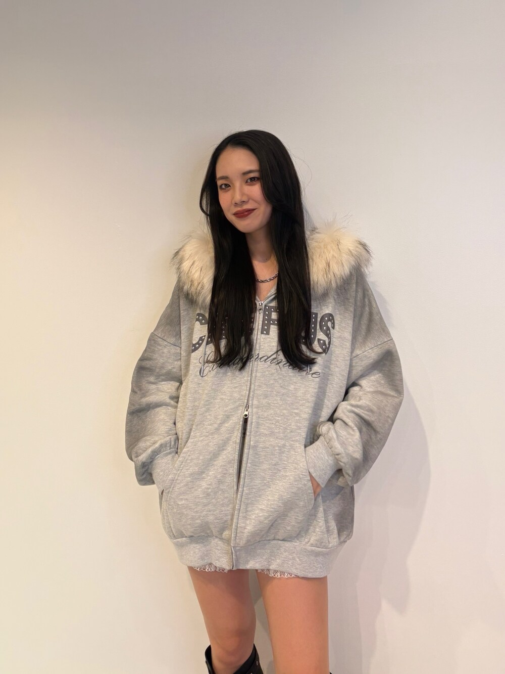 グレー系のパーカー、ブラック系のブーツを着用したレディースの秋コーディネートの4枚目の写真