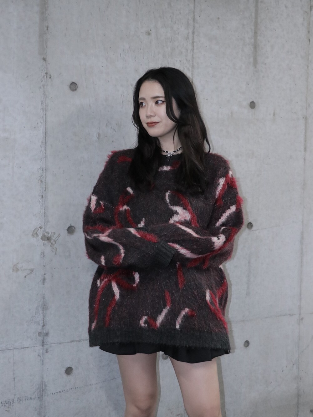 ブラック系のニット/セーター、ブラック系のスカート、ブラック系のブーツを着用したレディースの秋コーディネートの3枚目の写真