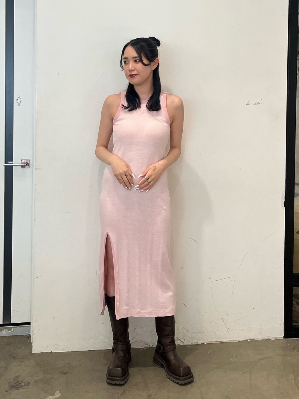 ピンク系のワンピース、ホワイト系のスカート、ブラウン系のブーツを着用したレディースの春コーディネートの4枚目の写真