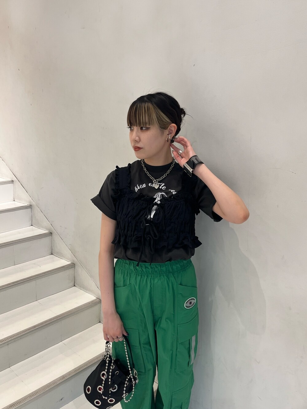 グリーン系のカーゴパンツ、ブラック系のベスト、グレー系のTシャツ/カットソーを着用したレディースの夏コーディネートの4枚目の写真