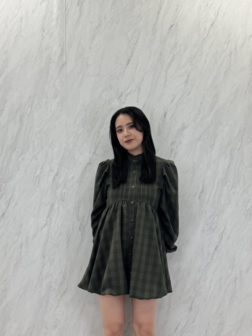 グリーン系のワンピースを着用したレディースの秋コーディネートの3枚目の写真