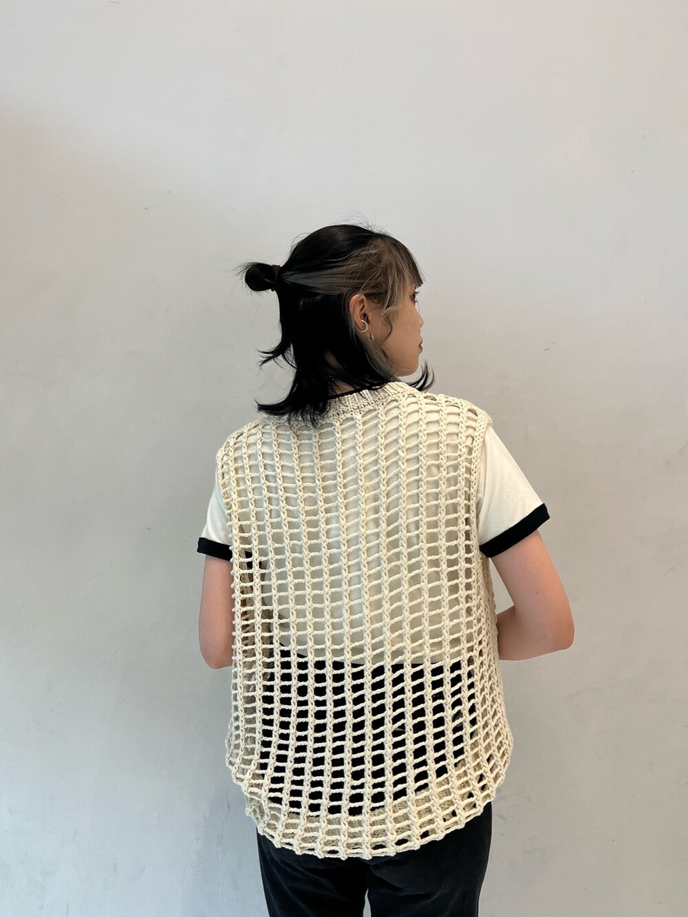 ブラック系のデニムパンツ、ホワイト系のTシャツ/カットソー、ホワイト系のベストを着用したレディースの春コーディネートの5枚目の写真