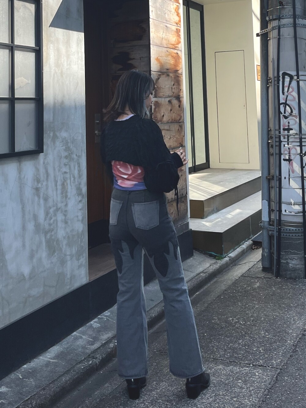 ブラック系のデニムパンツ、ブラック系のカーディガン/ボレロ、パープル系のTシャツ/カットソーを着用したレディースの春コーディネートの3枚目の写真