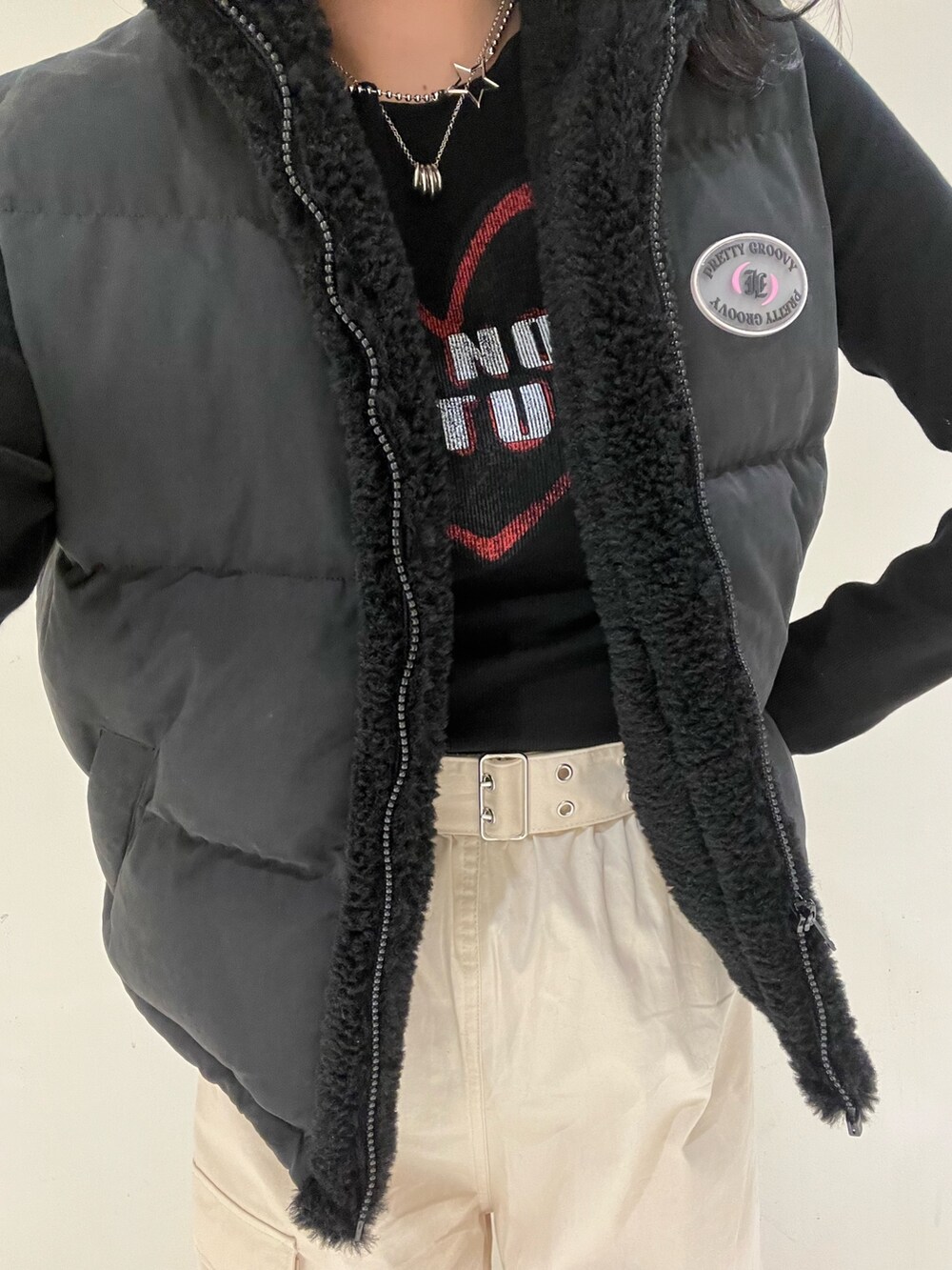 ブラック系のダウンベスト、ホワイト系のカーゴパンツ、ブラック系のTシャツ/カットソーを着用したレディースの秋コーディネートの7枚目の写真