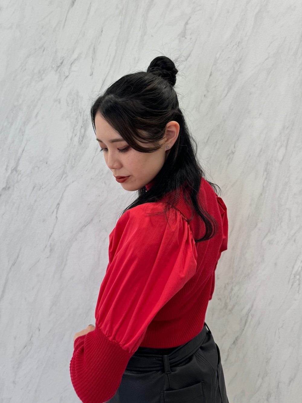 レッド系のニット/セーター、ブラック系のスカート、ブラック系のブーツを着用したレディースの夏コーディネートの5枚目の写真