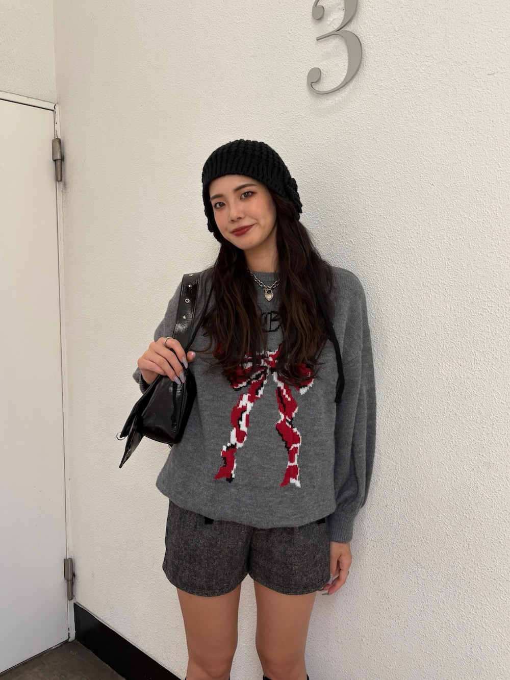 グレー系のニット/セーター、グレー系のその他パンツ、ブラック系のショルダーバッグを着用したレディースの秋コーディネートの3枚目の写真