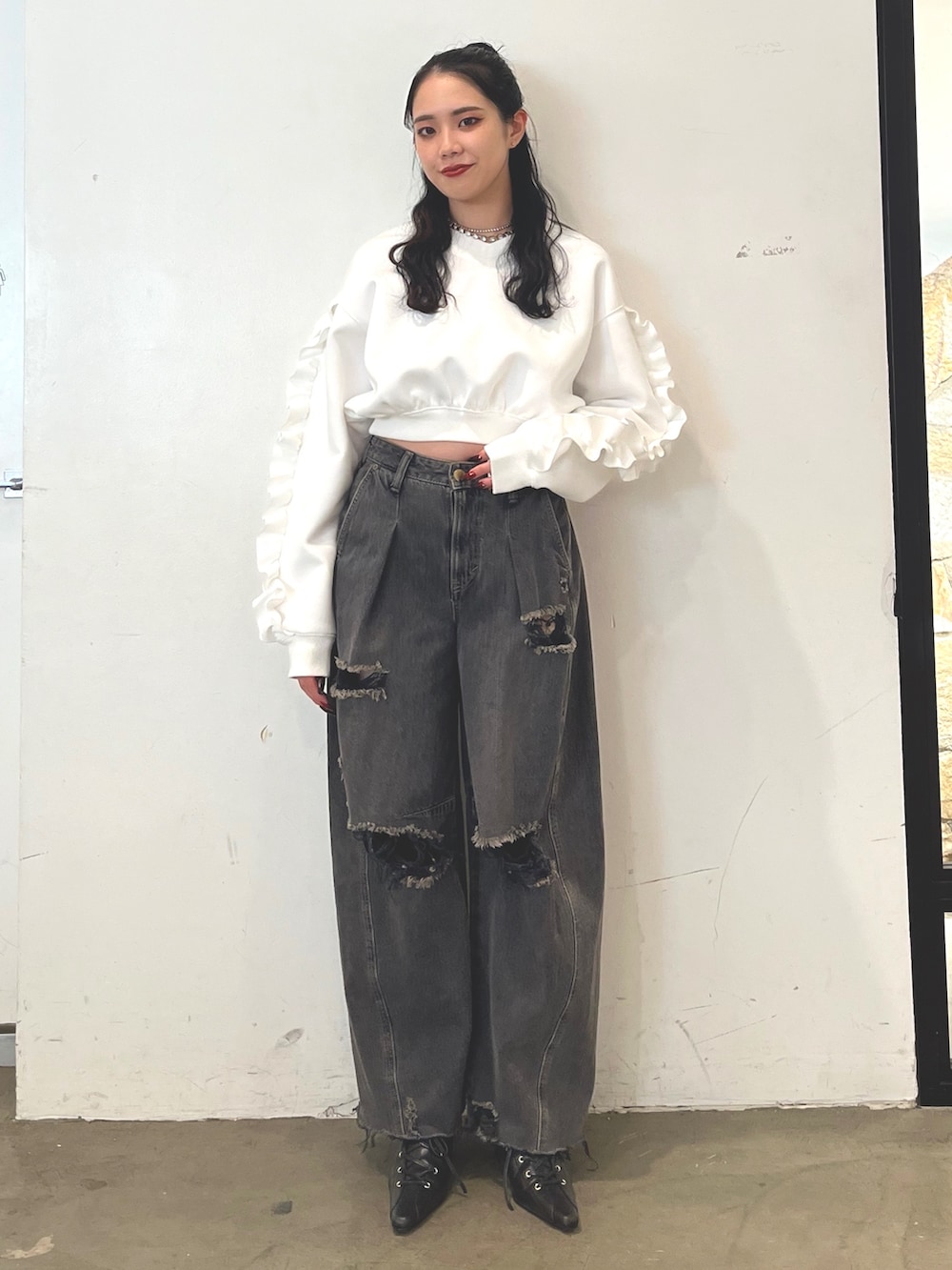 ブラック系のデニムパンツ、ブラック系のパンプス、ホワイト系のスウェットを着用したレディースの冬コーディネートの2枚目の写真