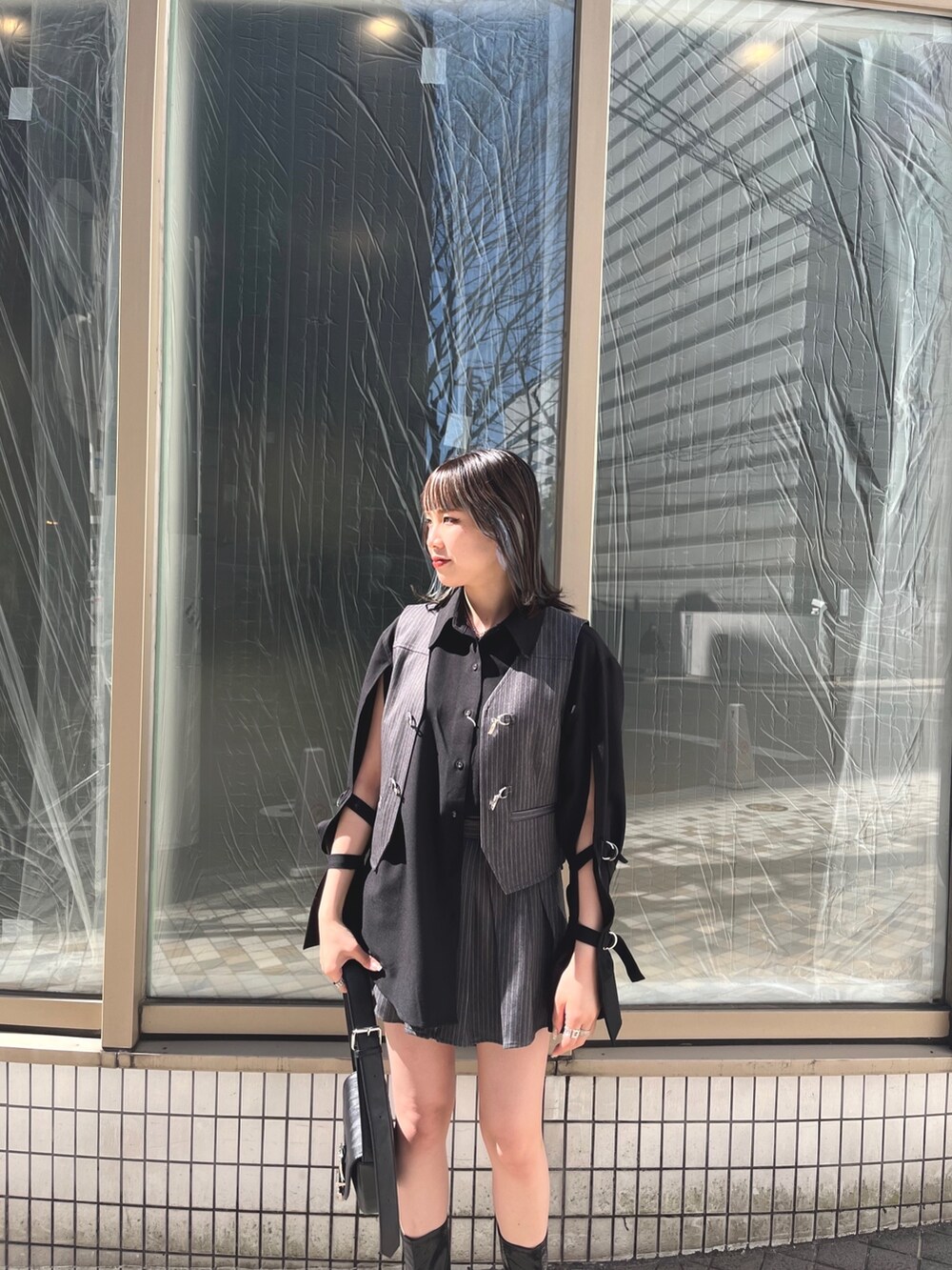 ブラック系のシャツ/ブラウス、グレー系のベスト、ブラック系のブーツを着用したレディースの春コーディネートの5枚目の写真