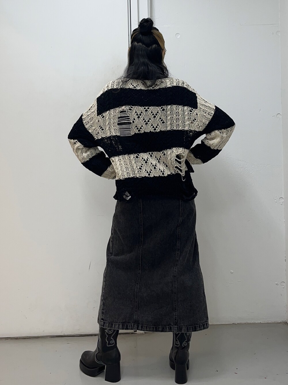 ブラック系のニット/セーター、ブラック系のワンピース、ブラック系のブーツを着用したレディースの冬コーディネートの2枚目の写真