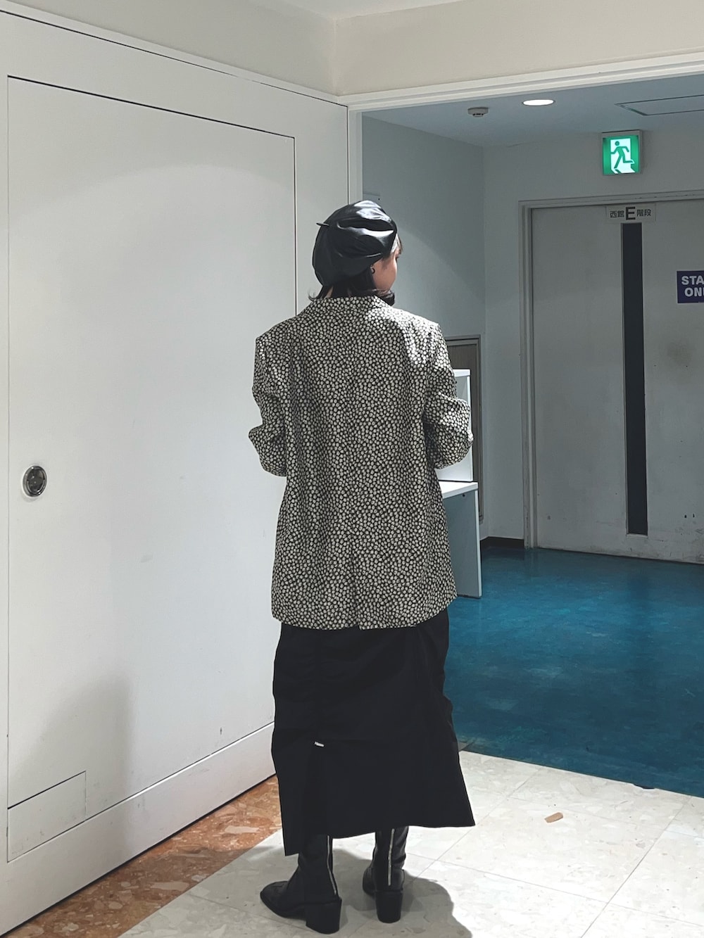 ブラック系のスカート、ブラック系のテーラードジャケット、ホワイト系のTシャツ/カットソーを着用したレディースの春コーディネートの3枚目の写真