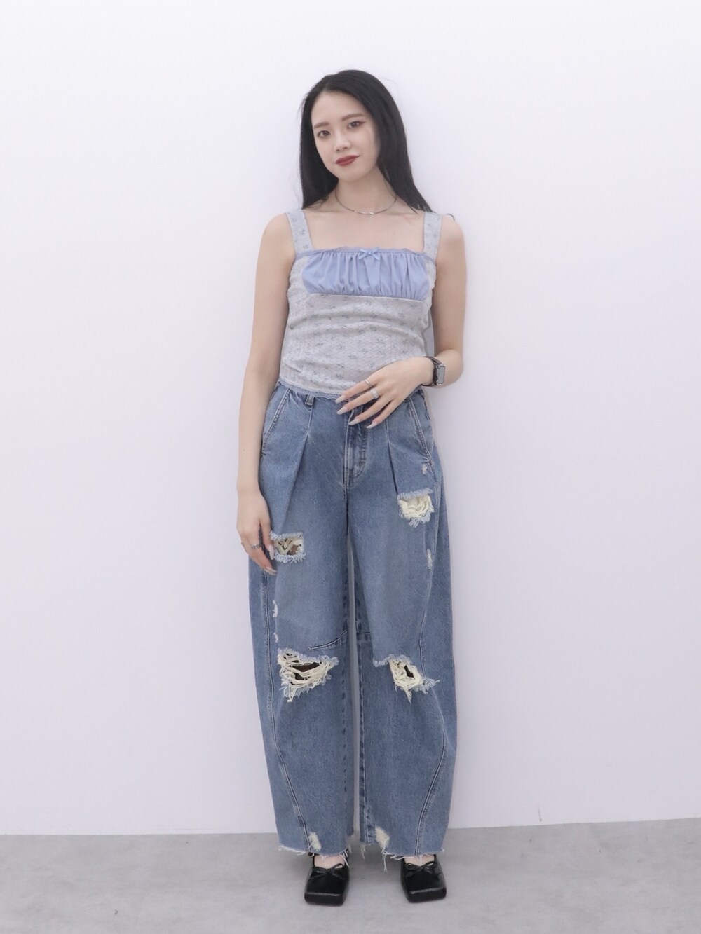 ブルー系のデニムパンツ、グレー系のキャミソール、ブラック系のパンプスを着用したレディースの冬コーディネートの2枚目の写真