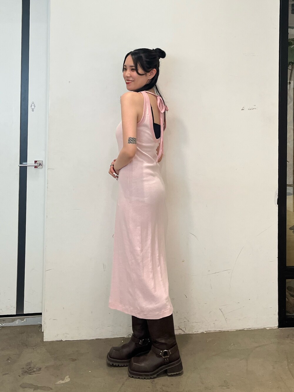 ピンク系のワンピース、ホワイト系のスカート、ブラウン系のブーツを着用したレディースの春コーディネートの5枚目の写真