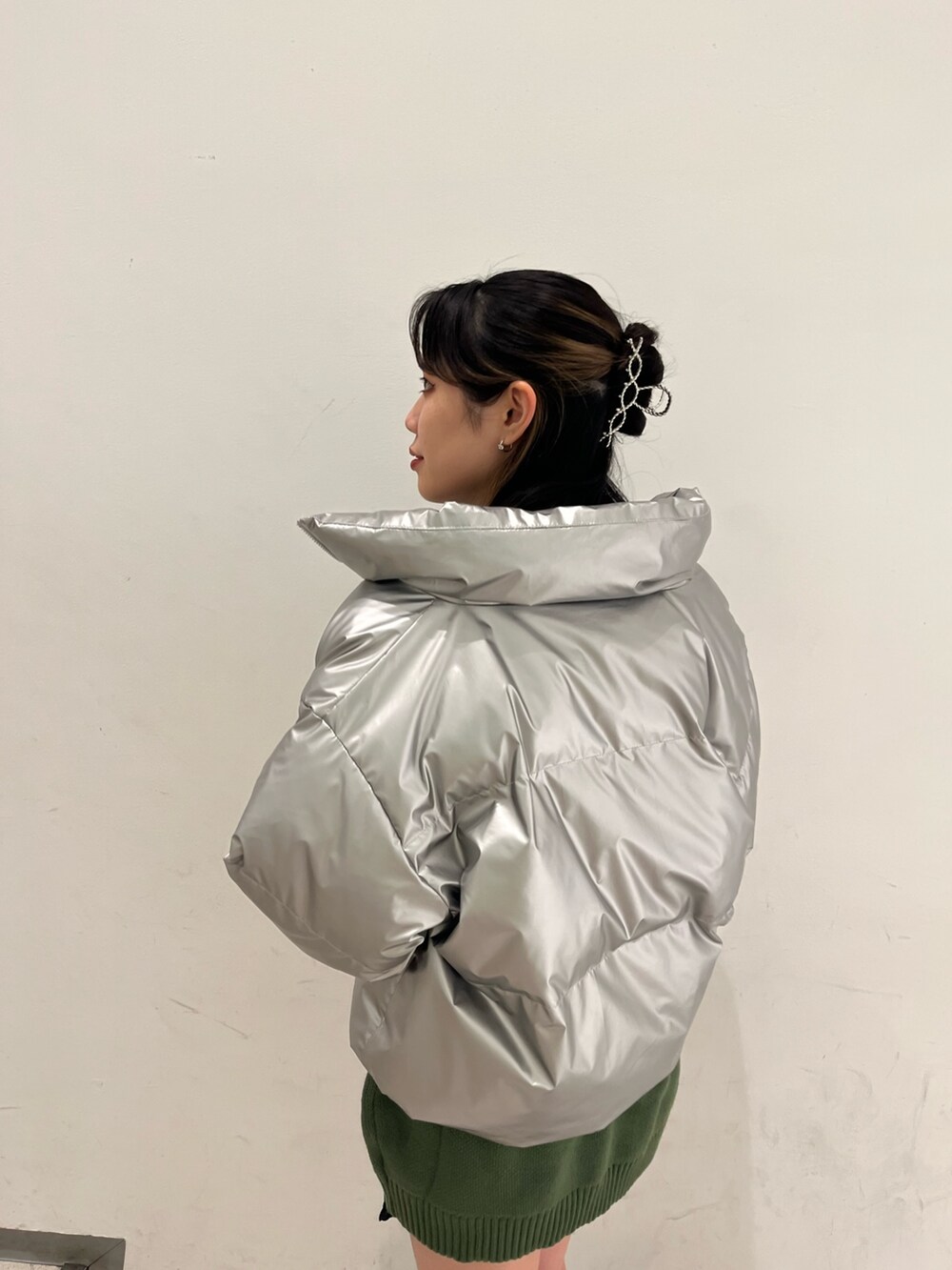 シルバー系のダウンジャケット/コート、グリーン系のニット/セーター、ブラック系のその他パンツを着用したレディースの冬コーディネートの4枚目の写真