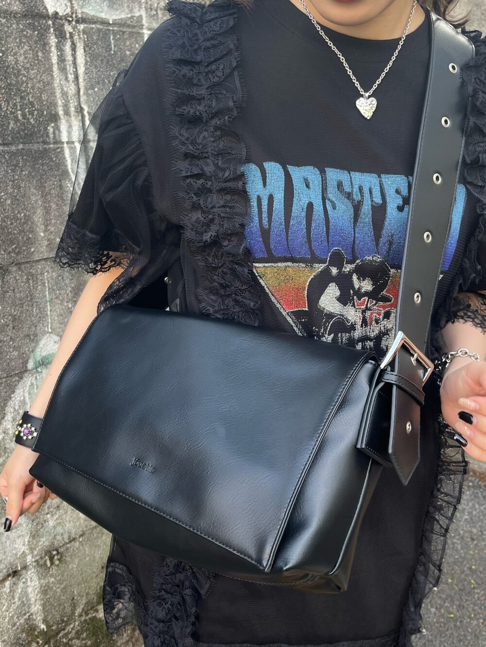 ブラック系のワンピース、ブラック系のメッセンジャーバッグ、ブラック系のブーツを着用したレディースの春コーディネートの10枚目の写真