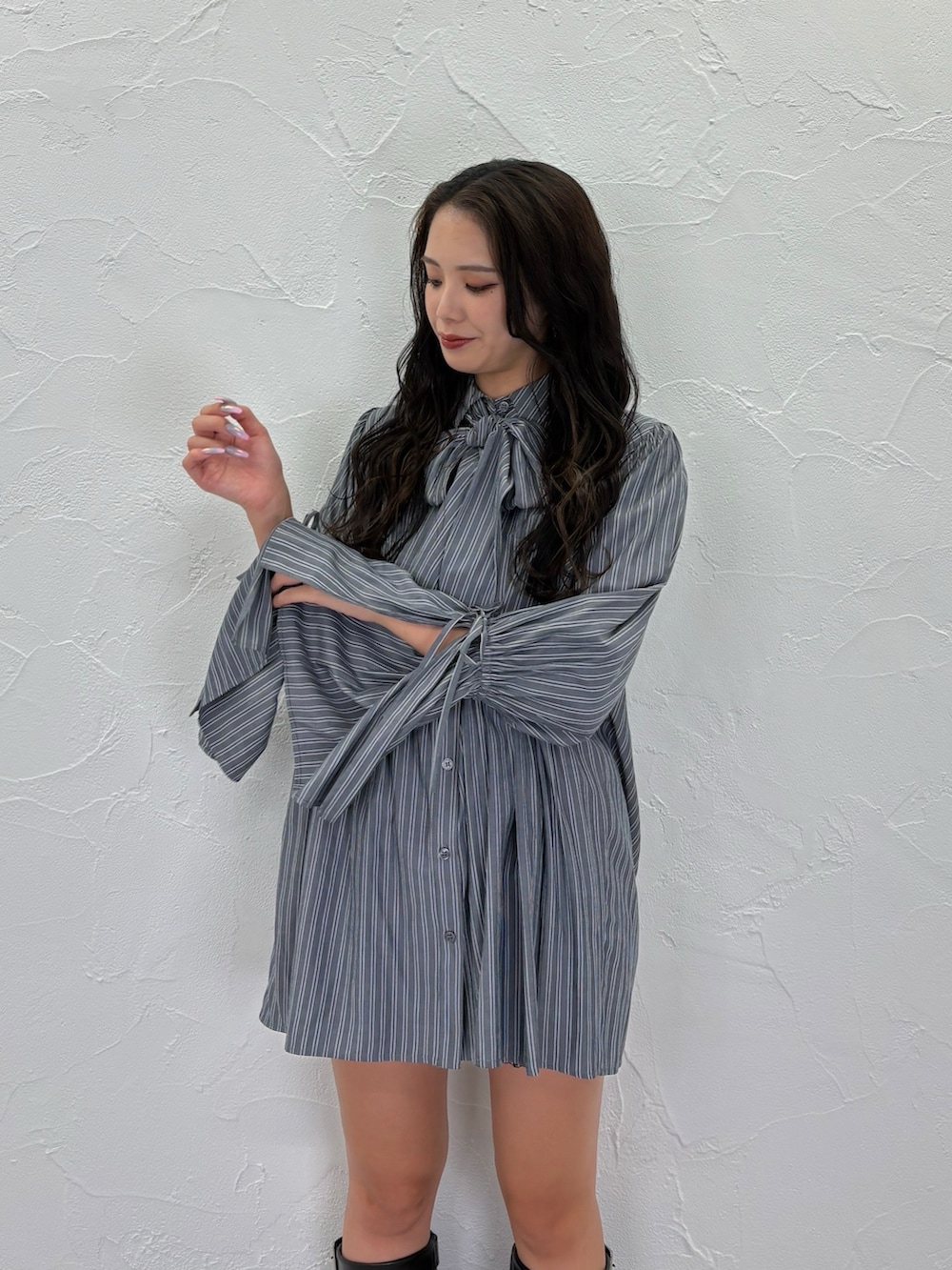 グレー系のシャツ/ブラウス、ブラック系のブーツを着用したレディースの秋コーディネートの3枚目の写真