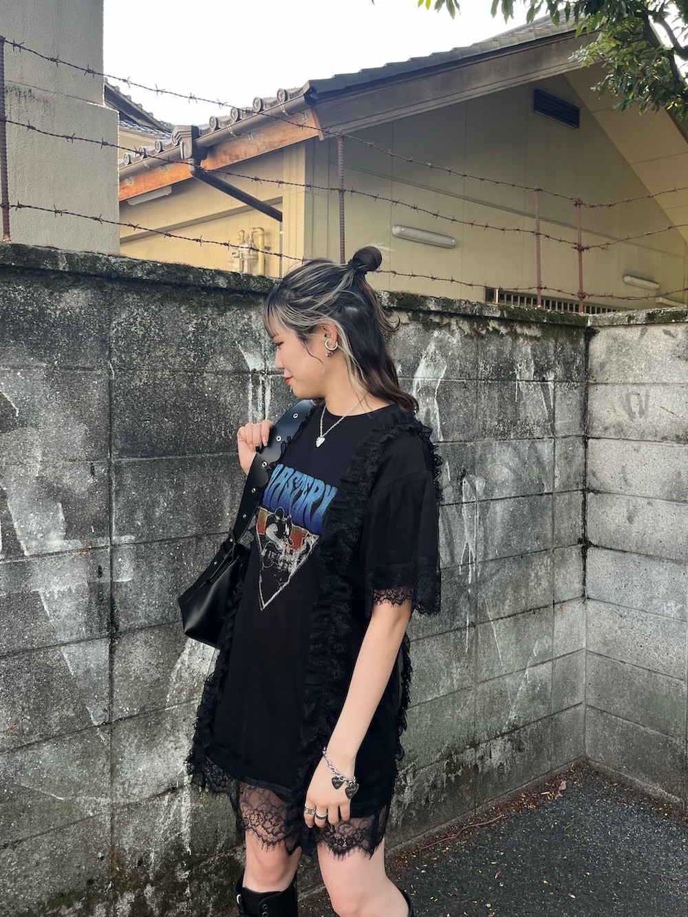 ブラック系のワンピース、ブラック系のメッセンジャーバッグ、ブラック系のブーツを着用したレディースの春コーディネートの5枚目の写真