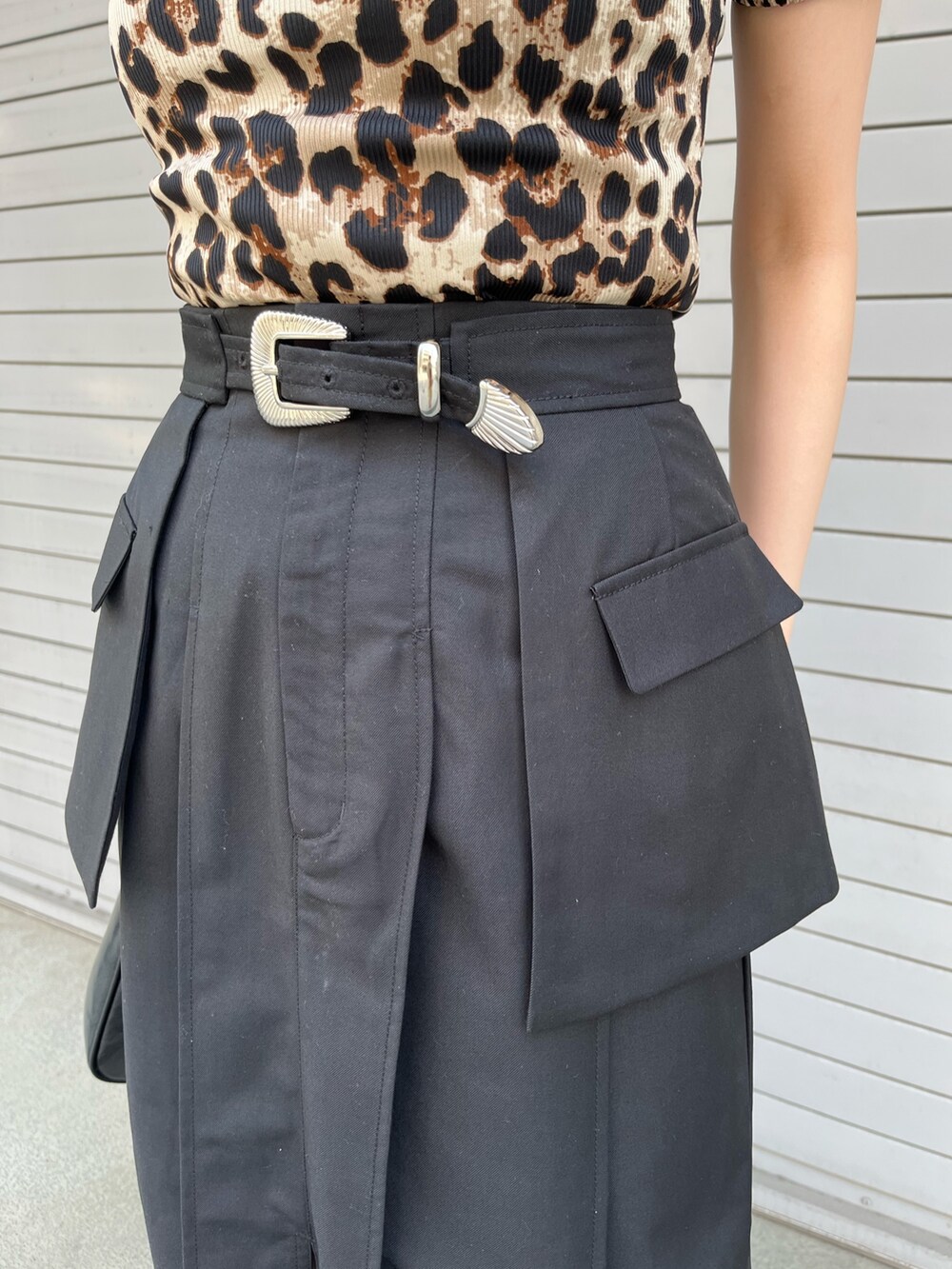 ブラック系のスカート、ブラック系のハンドバッグ、ベージュ系のTシャツ/カットソーを着用したレディースの春コーディネートの7枚目の写真