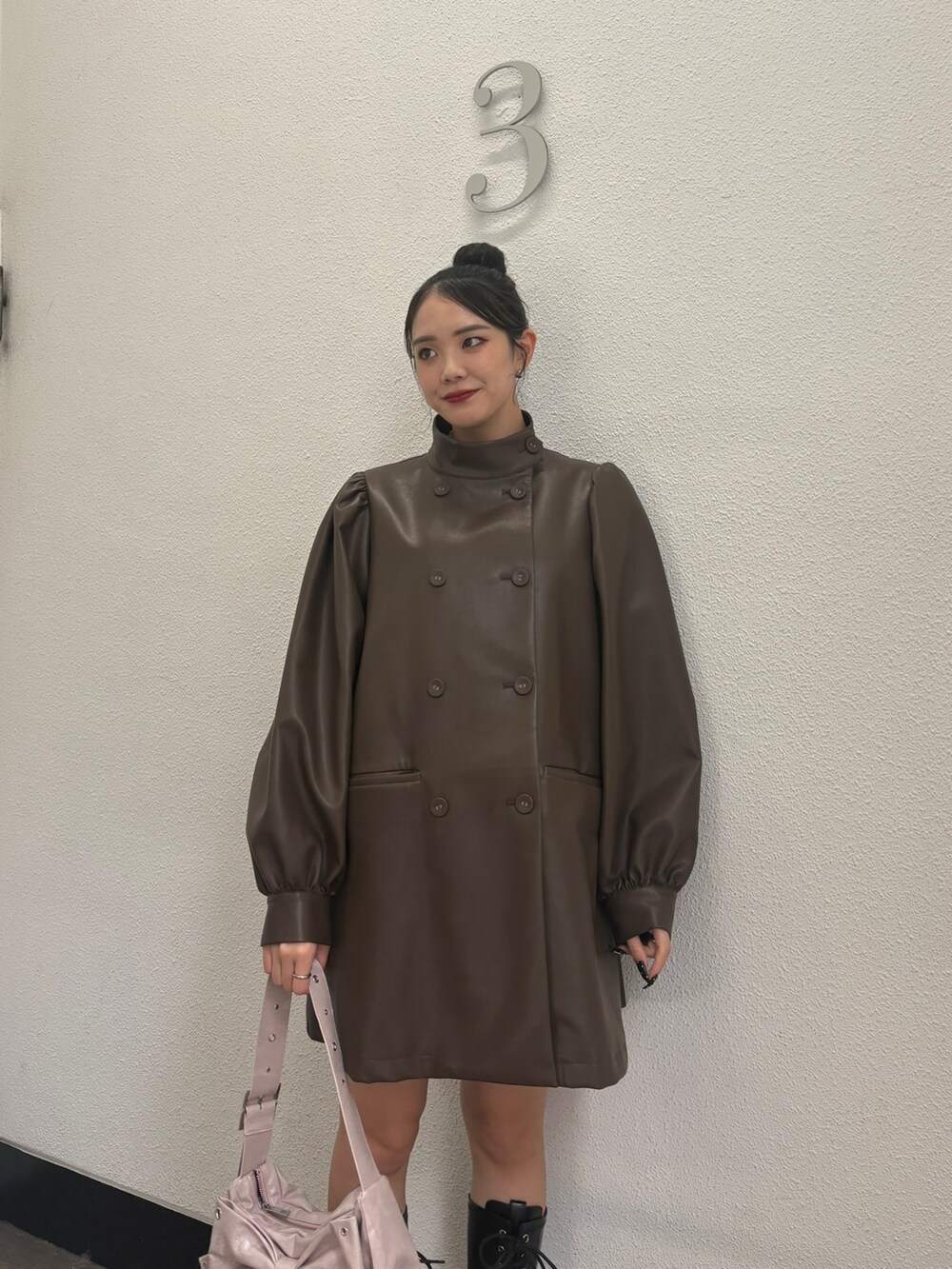 ブラウン系のその他アウター、ブラック系のブーツ、ピンク系のショルダーバッグを着用したレディースの秋コーディネートの5枚目の写真