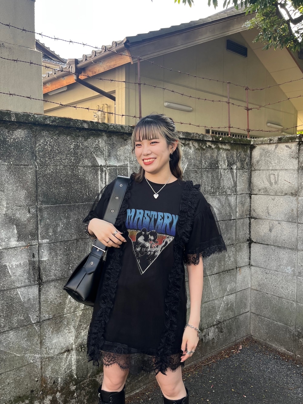 ブラック系のワンピース、ブラック系のメッセンジャーバッグ、ブラック系のブーツを着用したレディースの春コーディネートの4枚目の写真