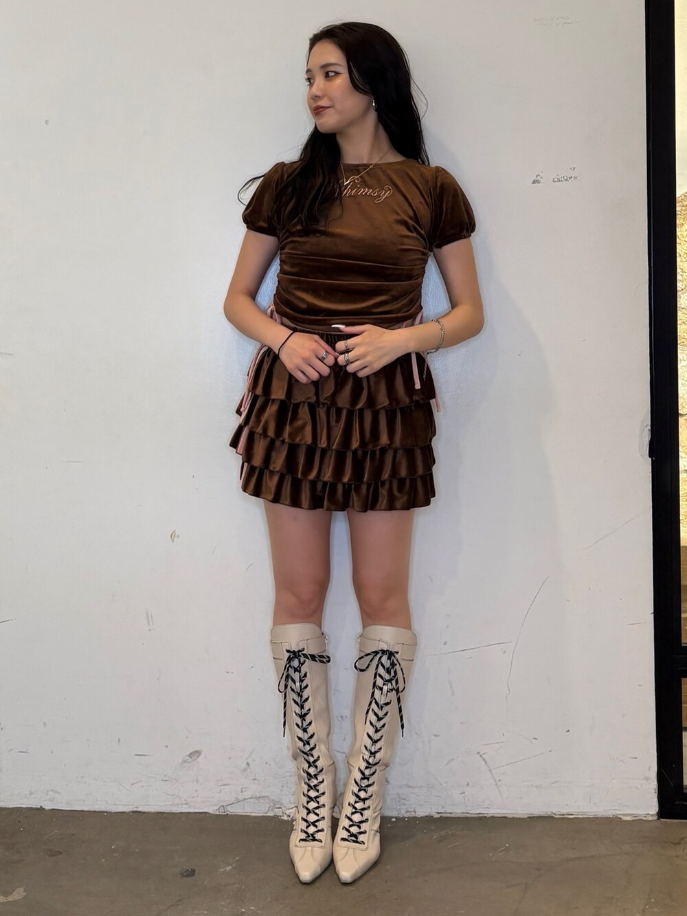 ブラウン系のスカート、ブラウン系のTシャツ/カットソー、ホワイト系のブーツを着用したレディースの夏コーディネートの4枚目の写真