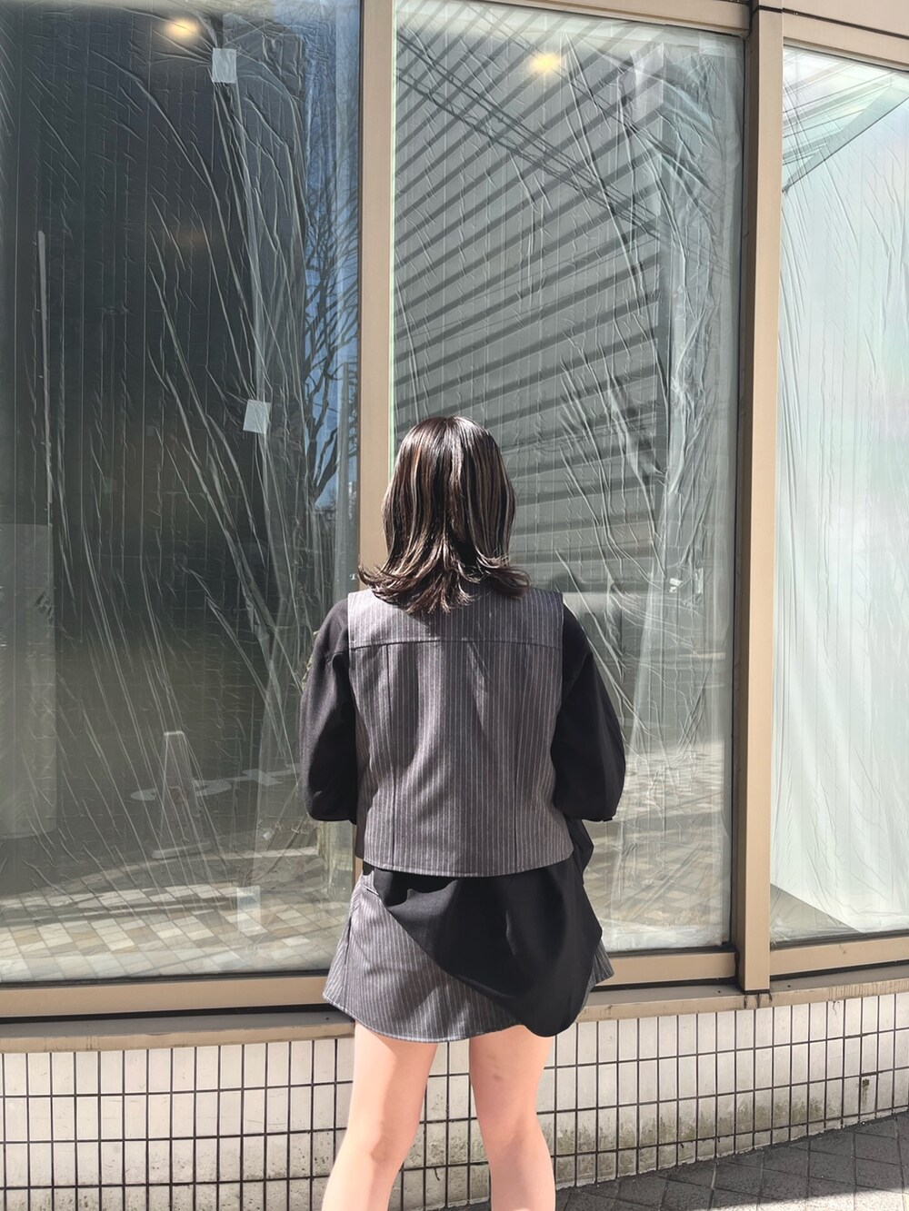 ブラック系のシャツ/ブラウス、グレー系のベスト、ブラック系のブーツを着用したレディースの春コーディネートの6枚目の写真