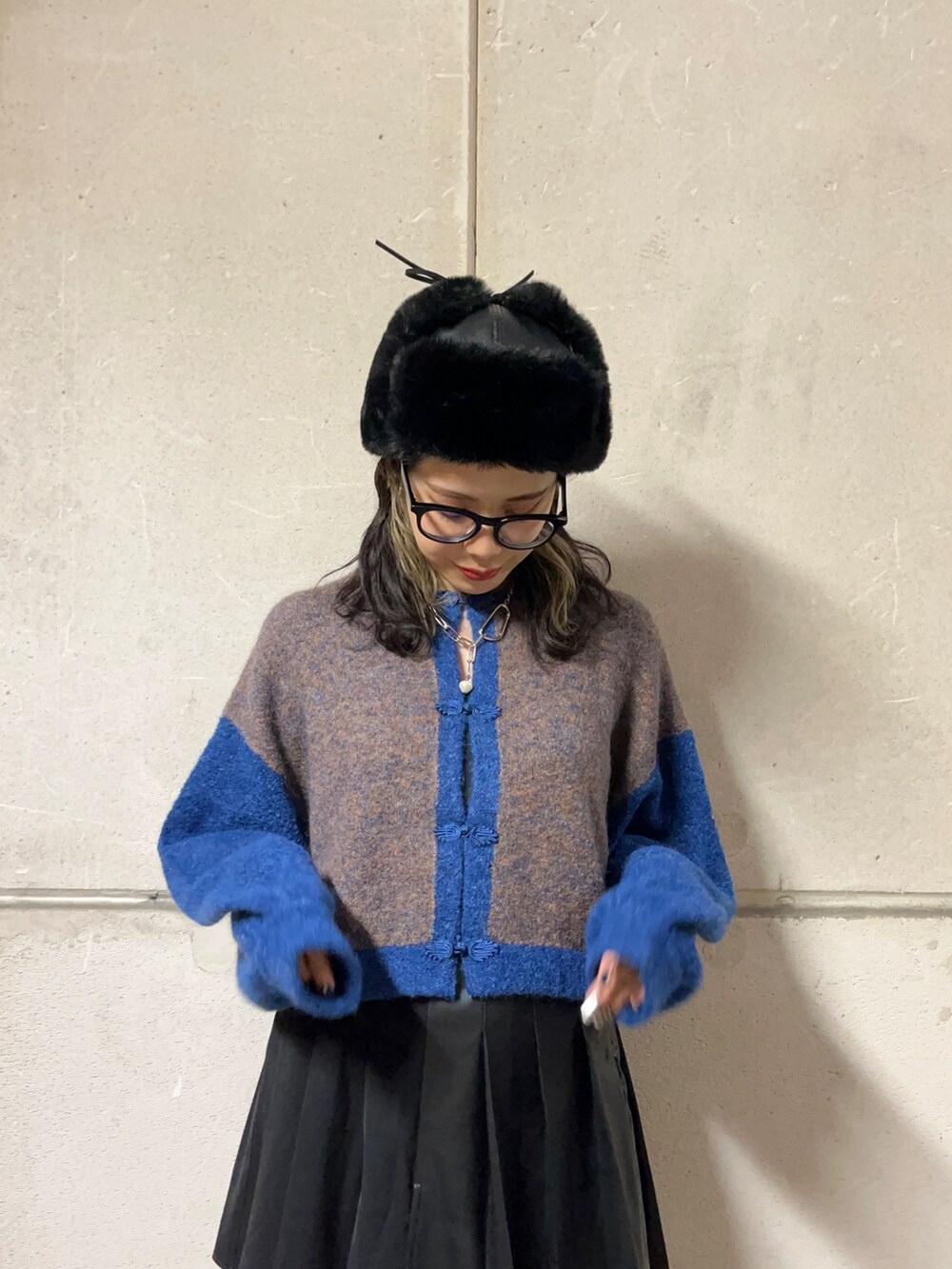 ブルー系のカーディガン/ボレロ、ブラック系のスカート、ブラック系のブーツを着用したレディースの冬コーディネートの4枚目の写真