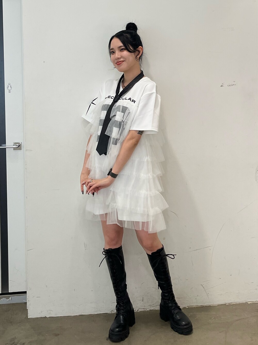 ホワイト系のワンピース、ブラック系のブーツを着用したレディースの春コーディネートの2枚目の写真